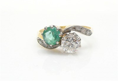 Lot 559 - An Emerald and Diamond Twist Ring, a round brilliant cut emerald and a round brilliant cut...