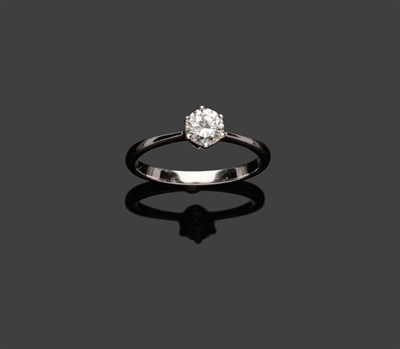 Lot 567 - A Diamond Solitaire Ring, a round brilliant cut diamond held in a six claw setting to a tapered...