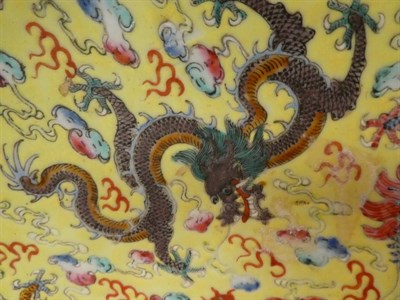 Lot 38 - A Chinese porcelain yellow ground dragon dish, decorated with nine dragons amongst clouds, seal...