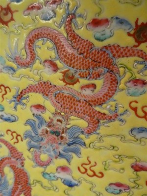 Lot 38 - A Chinese porcelain yellow ground dragon dish, decorated with nine dragons amongst clouds, seal...