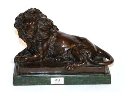 Lot 48 - After Barye, a bronze of a recumbent lion on a green marble base