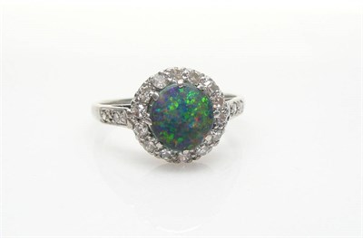 Lot 574 - A Black Opal and Diamond Cluster Ring, the round cabochon opal within a border of eight-cut...