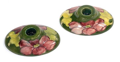 Lot 202 - A pair of Moorcroft pottery oval candle stands, paper labels to underside