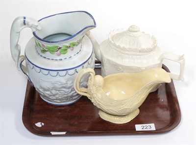 Lot 223 - A creamware shell moulded sauce boat; a Castelford type teapot and cover; and a relief moulded...