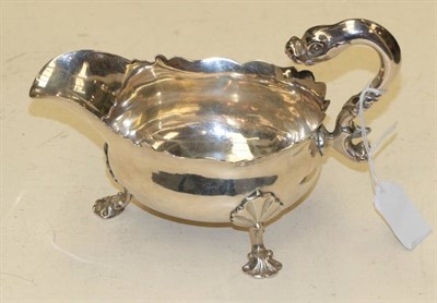 Lot 356 - A George II silver sauce boat, Henry Morris, London 1749, with flying dolphin handle, shaped...