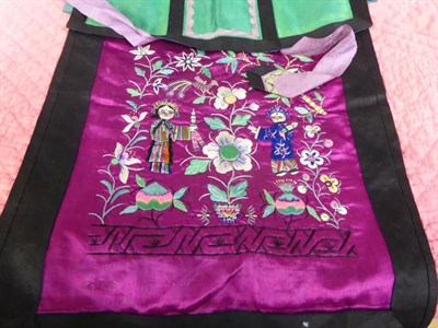 Lot 1051 - Assorted Chinese textiles including a magenta silk apron embroidered with figures, childs...