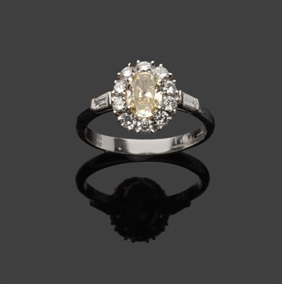 Lot 609 - A 18 Carat White Gold Diamond Cluster Ring, an oval cut diamond within a border of round...