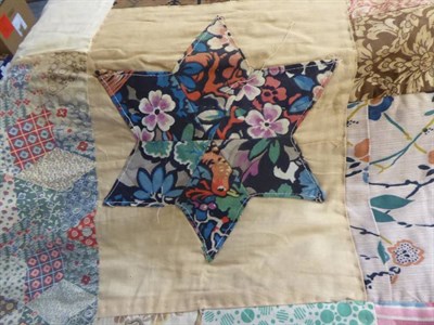 Lot 1056 - An early 20th century patchwork quilt with patched stars, central hexagonal motif patched with...