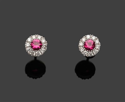 Lot 614 - A Pair of 18 Carat White Gold Ruby and Diamond Cluster Stud Earrings, each round brilliant cut ruby