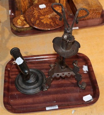 Lot 1295 - A wrought iron and steel candle holder, of stylised scissor form on figural tripod base,...