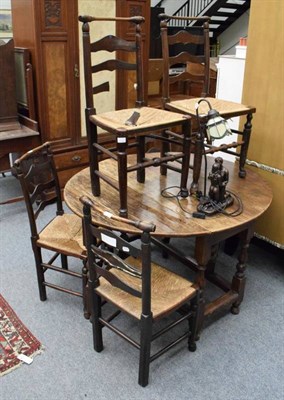 Lot 1356 - A set of five ladder back rush seated chairs together with an oak gateleg table an a lamp (7)