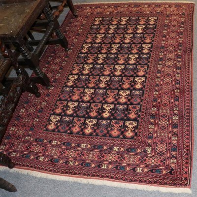 Lot 1389 - An Afghan rug, the indigo field of heraldic devices, enclosed by multiple borders, 182cm by 129cm