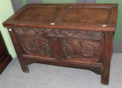 Lot 1403 - An early 18th century joined oak chest with hinged lid above carved panels and stile feet