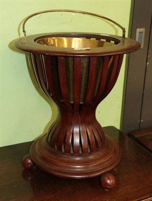 Lot 1405 - A mahogany and brass strung planter, 20th century, of circular form with pivoting brass handle...