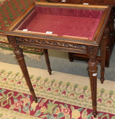 Lot 1437 - A carved walnut bijouterie table with glazed hinged lid and stop fluted legs