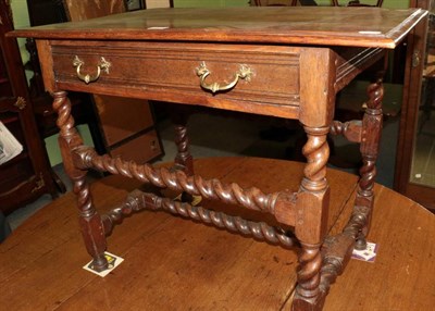 Lot 1476 - An oak side table, the moulded top above a long frieze drawer raised on spiral and block legs,...