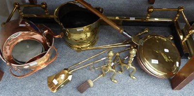 Lot 1092 - A group of metalwares including an extending fire curb; brass fire tools and andirons; brass helmet