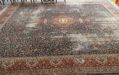 Lot 1153 - A large machine made carpet of classical Persian design, the deep indigo field with central...