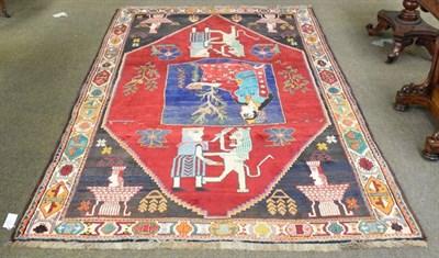 Lot 1154 - Unusual Kashgai rug, the raspberry field with Persepolis motifs and a central pictorial panel...