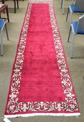 Lot 1156 - Tabriz runner signed, the plain filed enclosed by floral vine borders, 420cm by 86cm