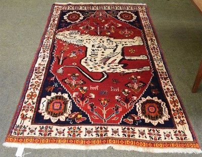 Lot 1163 - Unusual Kashgai rug, the crimson field depicting a stylised lion framed by spandrels and ivory...