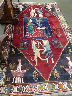 Lot 1163 - Unusual Kashgai rug, the crimson field depicting a stylised lion framed by spandrels and ivory...