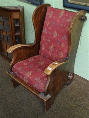 Lot 1261 - An Arts and Crafts style wing back armchair