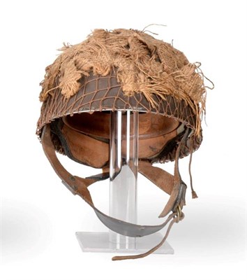 Lot 192 - A Second World War British Airborne Paratrooper's Helmet, with netting and hessian camouflage...
