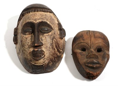 Lot 337 - An Igbo, Mask, with cream pigment to the face below a domed head with dentil carved...