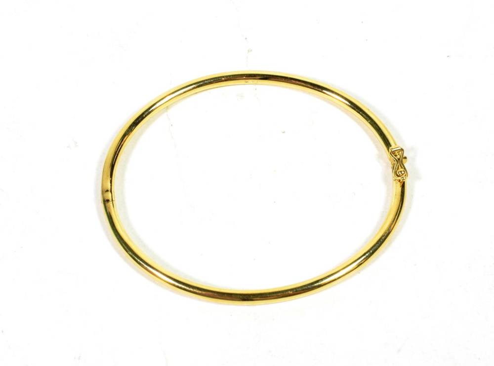 Lot 77 - An 18 carat gold hinged bangle, inner measurements 6cm by 5.3cm