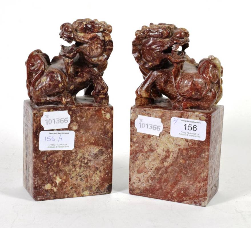 Lot 156 - A pair of soapstone carvings of temple lions on plinth bases