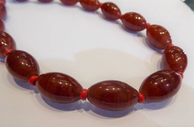 Lot 315 - A tin of butterscotch coloured bakelite beads, coral beads and other costume jewellery