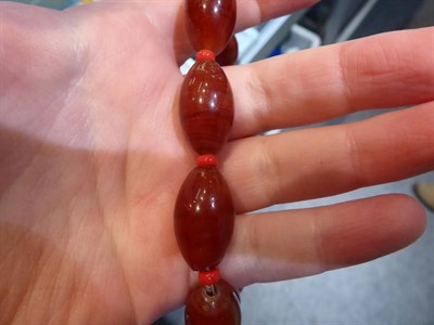 Lot 315 - A tin of butterscotch coloured bakelite beads, coral beads and other costume jewellery