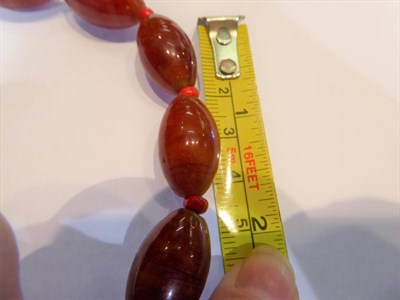 Lot 315 - A tin of butterscotch coloured bakelite beads, coral beads and other costume jewellery