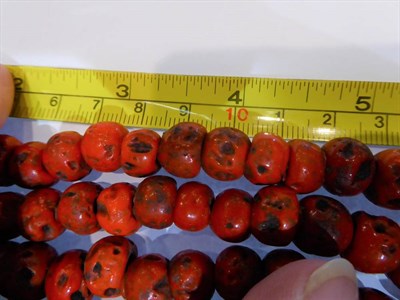 Lot 315 - A tin of butterscotch coloured bakelite beads, coral beads and other costume jewellery