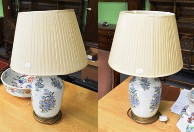 Lot 375 - A pair of floral painted porcelain table lamps