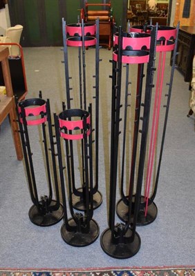 Lot 1109 - Two pairs of red and black painted metal ecclesiastical candle stands; and a single larger example