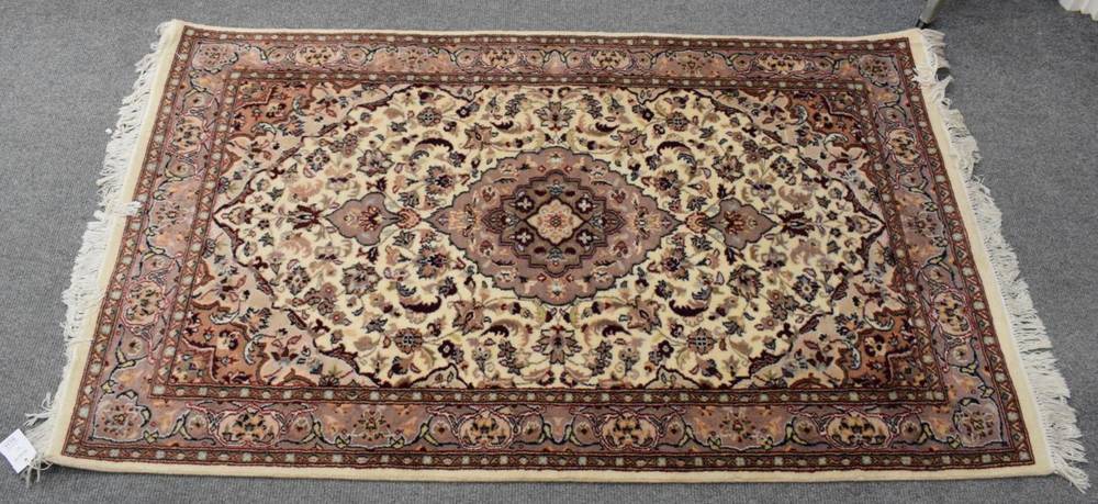 Lot 1178 - An Indian rug, the cream field of vines around a pole medallion, enclosed by narrow borders,...