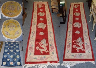 Lot 1189 - A pair of narrow Chinese runners, each with a column of dragons enclosed by lotus flower...