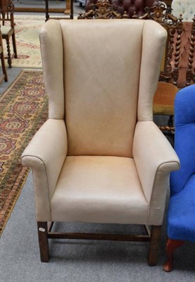 Lot 1248 - An oak framed leather winged back chair