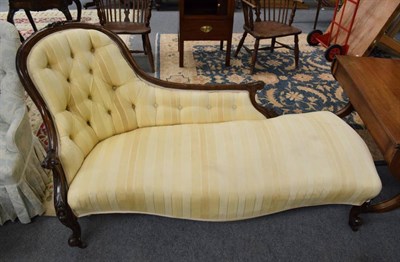 Lot 1315 - A Victorian walnut framed chaise lounge covered in yellow striped fabric, 180cm wide