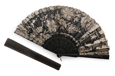 Lot 2125 - A Circa 1900 Spangled Fan, the monture of black wood, carved and pierced in a floral patterns...