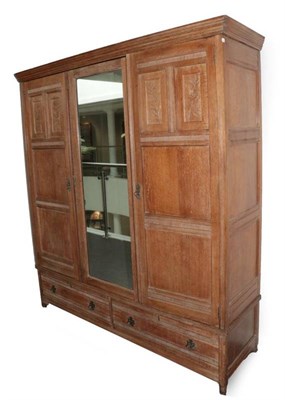 Lot 641 - An Arts & Crafts Limed Oak Wardrobe, designed by Frederick Muntzer, three-door two-sectional...