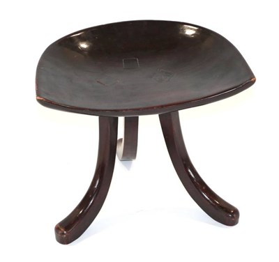 Lot 642 - A Liberty & Co Thebes Stool, stained mahogany, the dished top on three curved legs, unmarked, 36cm