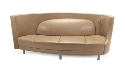 Lot 712 - A Three-Seater Curved Sofa, modern, covered in beige leather with stitched detail, oval padded back