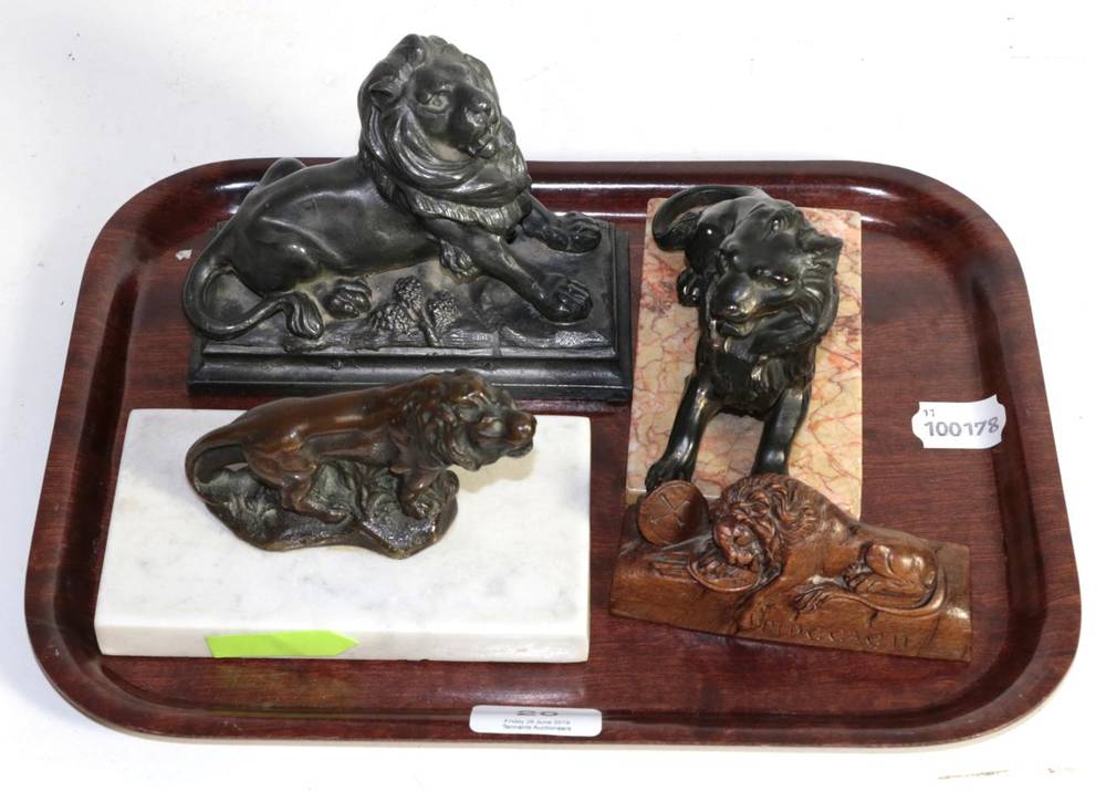 Lot 20 - A bronze model of a lion on a marble base, two further cast metal models of recumbent lions and...