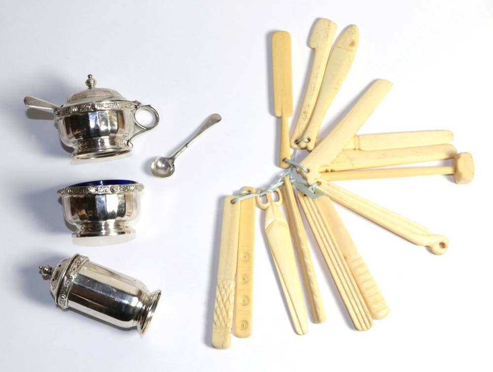 Lot 70 - A three piece silver condiment set; and a set of carved ivory children's teething toys