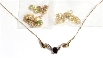 Lot 79 - A peridot pendant on a 9 carat gold chain and matching drop earrings, chain length 45.5cm; an...