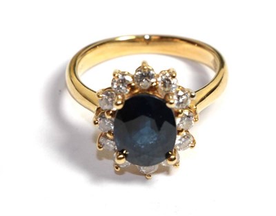 Lot 109 - A sapphire and diamond cluster ring, stamped '18K' '750', finger size K1/2