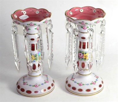 Lot 173 - A pair of white overlay and floral decorated pink glass table lustre candlesticks